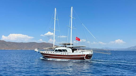 Türk bayraklı Gulet yatı, Fethiye'nin sakin sularında yelken açıyor.