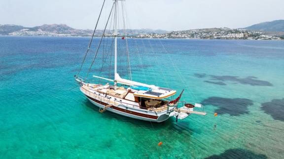 Entdecken Sie die Gulet Cosh, die friedlich auf dem türkisblauen Wasser von Bodrum treibt.