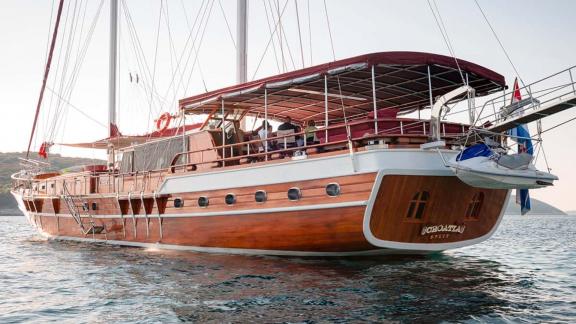 The wooden hull and spacious aft deck of gulet Croatia stand out with their elegant design on the sea.