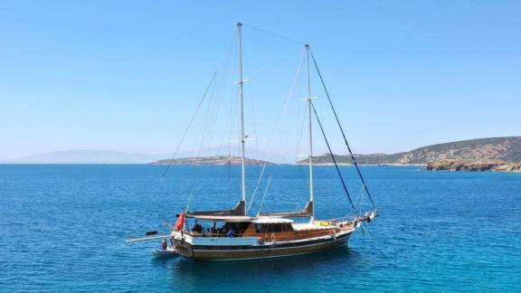 Die Gulet Deniz Kızı A ankert im türkisblauen Wasser vor der Küste von Bodrum, ideal für entspannte Segeltörns.