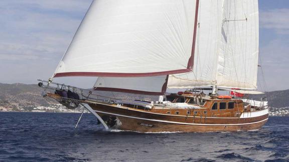 Traditional wooden gulet with white sails, sailing in the blue waters near Bodrum.