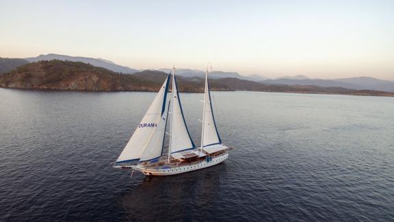 The luxurious gulet Duramaz with 6 cabins sails in calm waters off the picturesque coast of Fethiye.