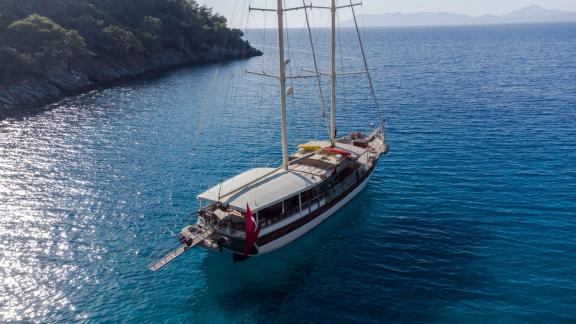 The Gulet Efe Burak peacefully anchored off a pristine, wooded coastline.