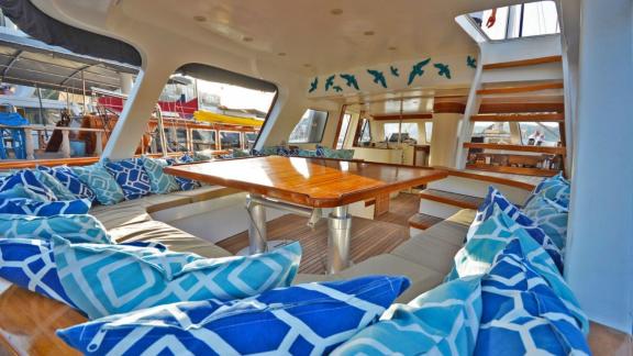 Among Marmaris yacht rental options Eloa aft deck shows covered seating area and dining table for comfort.