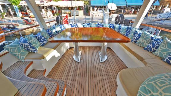 Unter den Yachtcharter Optionen in Marmaris zeigt Eloa Achterdeck mit großem Tisch und umlaufender Sitzgruppe.