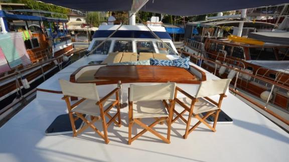 Among Marmaris yacht rental options Eloa front deck shows table and seating area for relaxation.