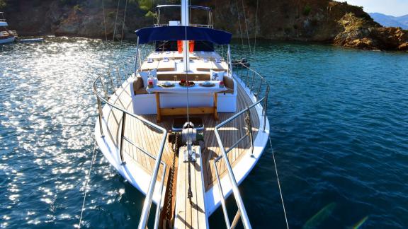 Die Gulet Emir Bey 1 bietet auf dem Vorderdeck einen stilvollen Essbereich, umgeben von klarem Wasser und sonniger Atmos