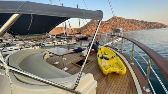 Sun deck of Gulet Enver Aga in Marmaris, featuring comfortable seating and a kayak for adventurers.