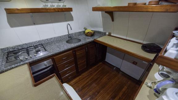 Modern kitchen on the gulet with stove, sink, and granite countertops.