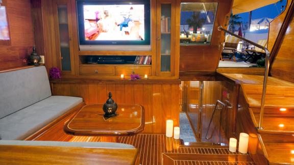 A cosy living area on board the Flas VII with a seating area, a television and atmospheric lighting.