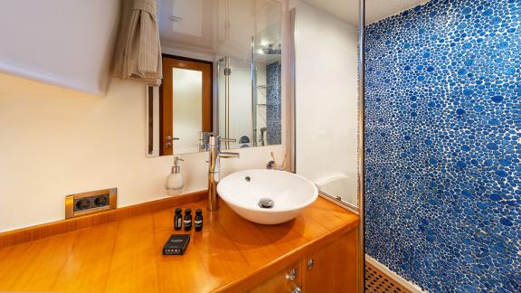 In Göcek gulet charter option Getaway bathroom with sink shower mirror and modern design clearly visible.