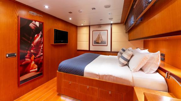 In Göcek gulet charter option Getaway cabin with double bed tv unit and cozy interior visible.