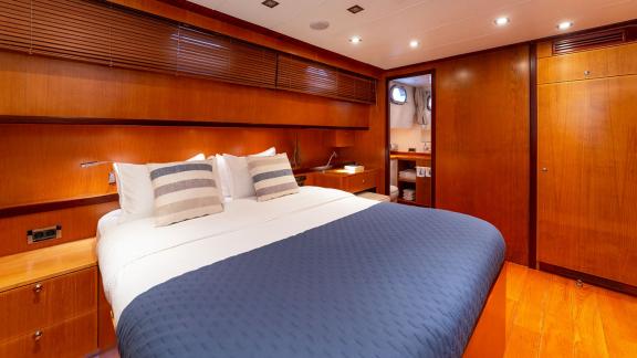 In Göcek gulet charter option Getaway cabin with double bed storage and bathroom entrance visible.