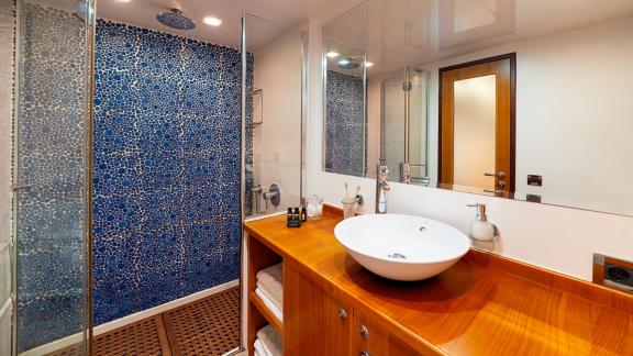 In Göcek gulet charter option Getaway bathroom with shower cabin sink mirror and modern design visible.