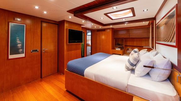 In Göcek gulet charter option Getaway master cabin with large bed tv unit and spacious interior clearly visible.