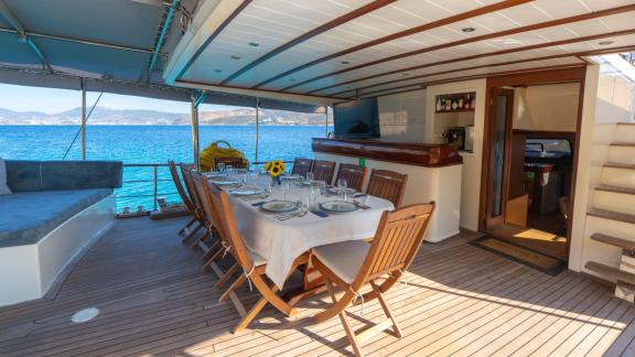 В Бодруме аренда гулета Giulia на корме стол для еды и барная зона.