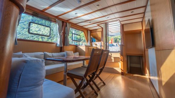 В Бодруме аренда гулета Giulia салон с диванами и обеденным столом.