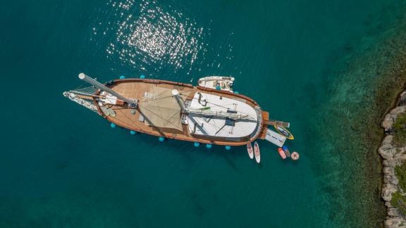 Гулет Green Ray стоит у Сплита, видны сапборды и прозрачная вода под ним с высоты птичьего полёта.
