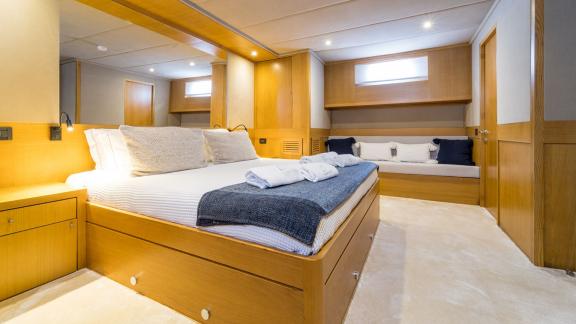 In Fethiye gulet charter option Happy Days master cabin with large bed and seating area visible.