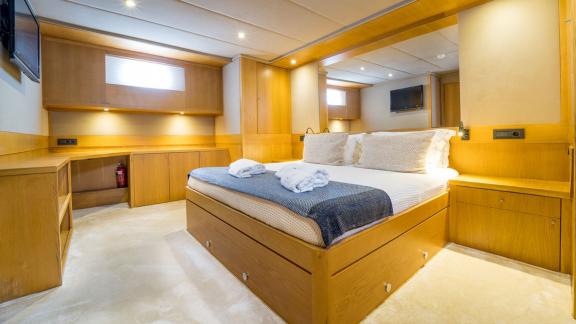 In Fethiye gulet charter option Happy Days master cabin with large bed and storage space visible.