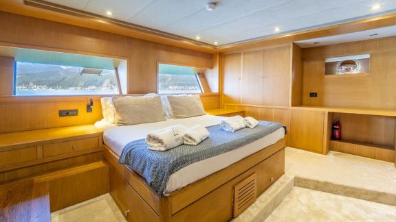 In Fethiye gulet charter option Happy Days master cabin with large bed and storage cabinets visible.