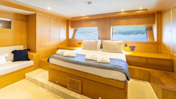 In Fethiye gulet charter option Happy Days master cabin with large bed and sea view window visible.