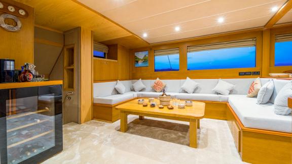 In Fethiye gulet charter option Happy Days interior salon with seating area and bar visible.