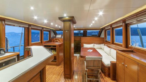 Interior of a luxurious sailing yacht with cosy seating area and panoramic windows off the coast of Bodrum.