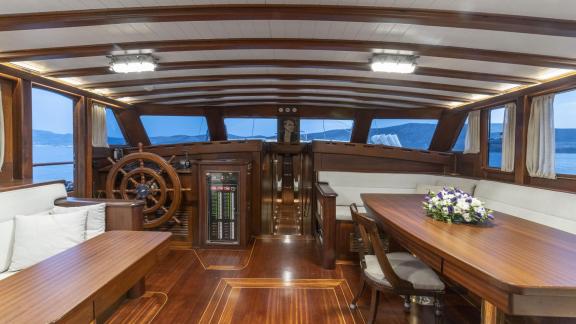 Elegant interior of the gulet yacht Jasemin 1 with steering wheel and dining table.