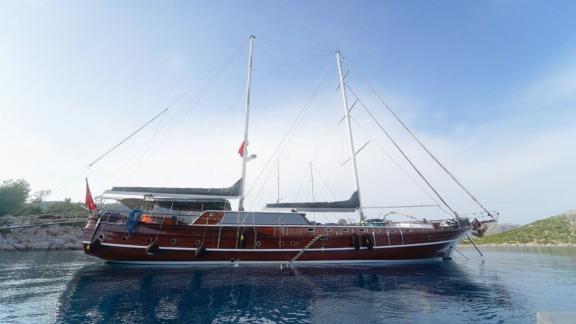 Holz-Gulet-Yacht liegt in ruhigem Gewässer und klarer Bucht vor Anker.