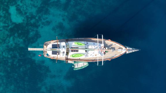На Родосе аренда гулета Lady Freya вид сверху в прозрачной воде с просторной палубой и зоной отдыха.