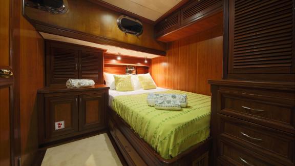 На Родосе аренда гулета Lady Freya каюта с большой кроватью шкафами и уютным интерьером для отдыха.