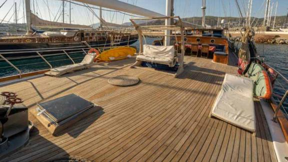 Das Deck einer traditionellen türkischen Gulet im Hafen von Bodrum, Türkei. Auf dem Holzdeck befinden sich bequeme Sitzg