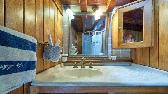 Washbasin and mirror in a bathroom on a gulet with wooden interior.