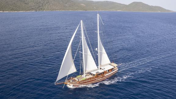 The Gulet Lorient, an elegant sailing ship with five cabins, sails under full sail through the blue waters of Bodrum.