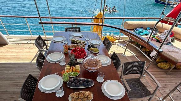 Auf der Mietgulet Mare Magico in Marmaris sind gedeckter Tisch, Früchte, Teller und Meer für Wochencharter zu sehen.