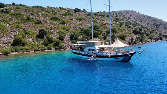 Bei Marmaris liegt die Mare Magico in türkisblauer Bucht, mit zwei Masten, Sonnensegel und Badebereich für Wochencharter