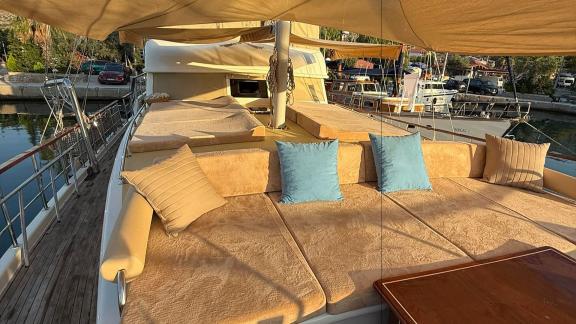 Auf der Mietgulet Mare Magico in Marmaris sind Vorderdeck, Sonnensegel, Polster und blaue Kissen zu sehen.