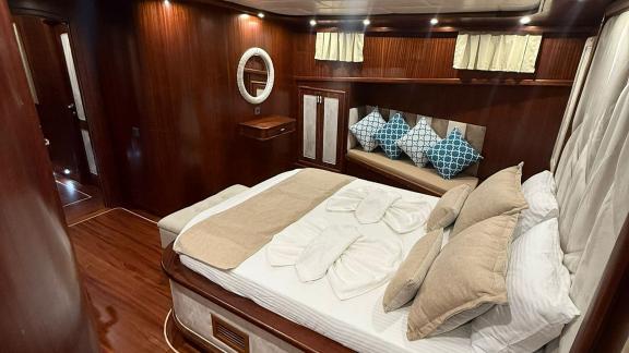 In der Mietgulet Mare Magico sind Doppelbett, Sofa, türkise Kissen und Holzinterieur für Wochencharter zu sehen.