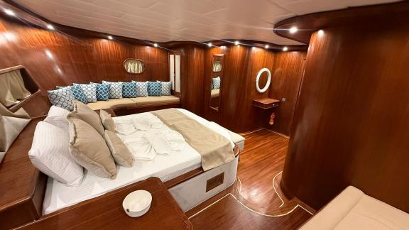 In der Mietgulet Mare Magico in Marmaris sind Doppelbett, Sofa, Holzdekor und warmes Licht zu sehen.