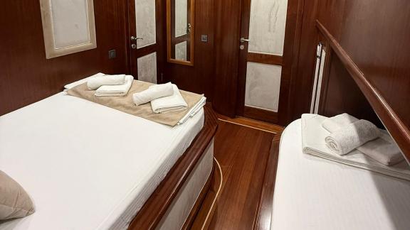 In der Mietgulet Mare Magico in Marmaris sind Doppelbett, Einzelbett, Handtücher und Holztüren zu sehen.