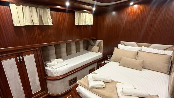 In der Mietgulet Mare Magico in Marmaris sind Doppelbett, Einzelbett, Schrank und Holzinterieur zu sehen.
