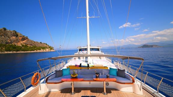 Cosy seating area on the Gulet Maya, with a magnificent view of the blue sea and the coast of Fethiye.