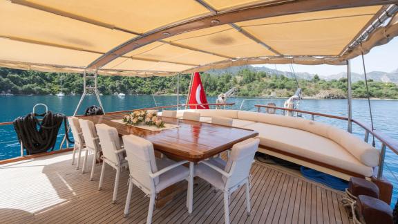 Auf dem Heck der Gulet Memo aus Marmaris befindet sich ein großer Esstisch mit Sonnenschutz.