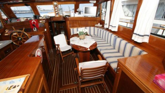 Stylish salon on Gulet Miramare with wood paneling and comfortable seating area, perfect for cozy evenings onboard.