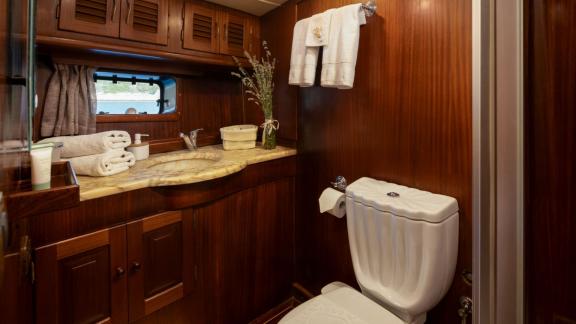 Geräumiger Waschbereich, Holzschränke und Marmordetails sorgen für ein stilvolles Ambiente.