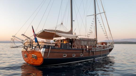 Traditionelle Gulet Pacha aus Holz bei Sonnenuntergang, vor Anker vor Split – aufgenommen von hinten.