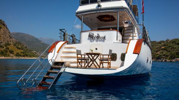 Zu sehen sind die Badeleiter, der Sitzbereich am Heck und die Plattform der Perdue in einer Bucht von Fethiye.
