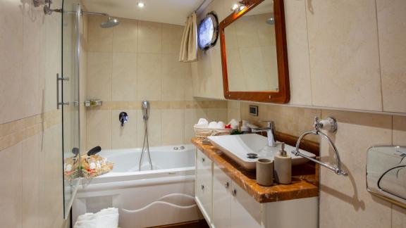 Im Badezimmer der Perdue in Fethiye sind Badewanne, Waschtisch und separater Duschbereich zu sehen.