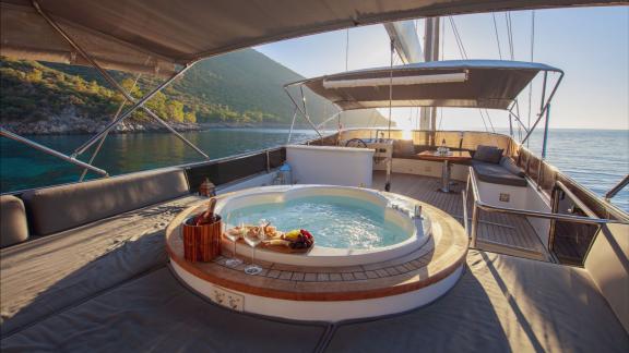 Auf dem Oberdeck der Perdue in Fethiye sind Whirlpool, Sitzbereich und Meerblick zu sehen.